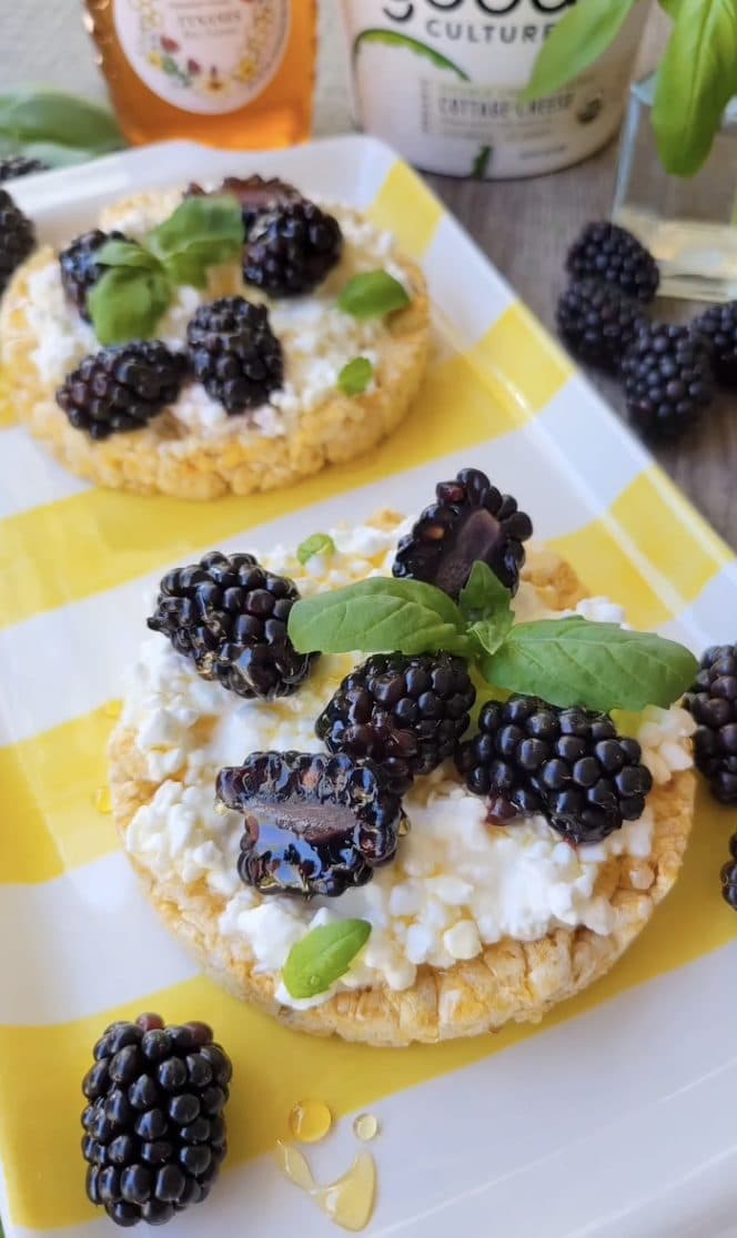 Rice cakes topped with cottage cheese, blackberries, basil and a drizzle of honey